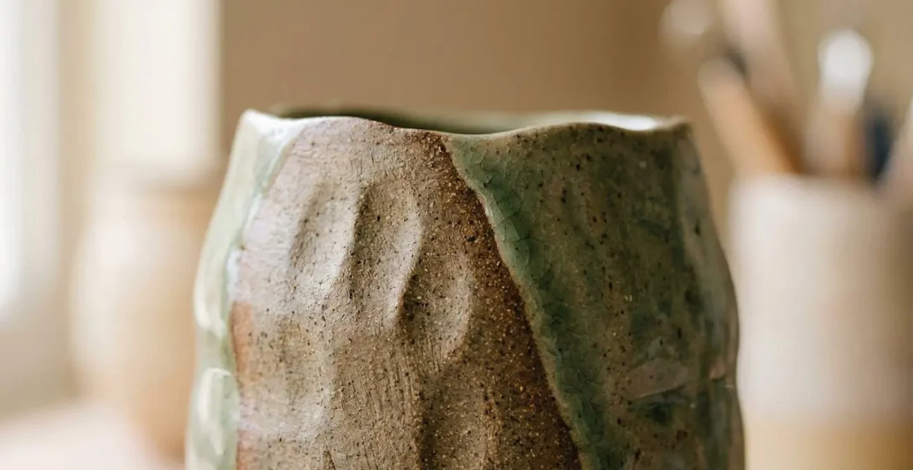 Vue rapprochée d'une pièce de céramique artisanale présentant des textures naturelles et des imperfections wabi-sabi