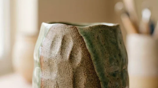 Vue rapprochée d'une pièce de céramique artisanale présentant des textures naturelles et des imperfections wabi-sabi