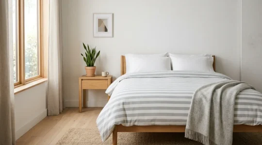 Chambre élégante avec linge de lit à rayures horizontales larges créant une illusion d'espace