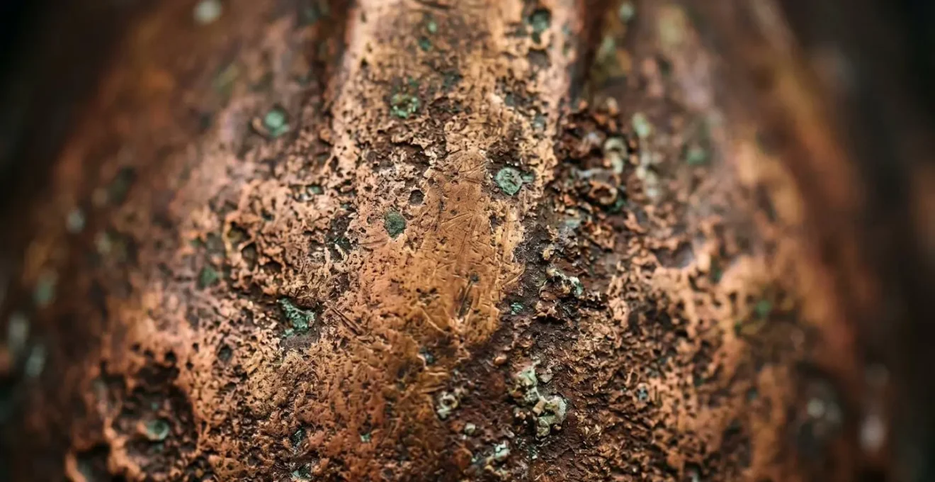 Détail macro de la patine naturelle sur un hublot en laiton ancien montrant les variations de couleur et la texture