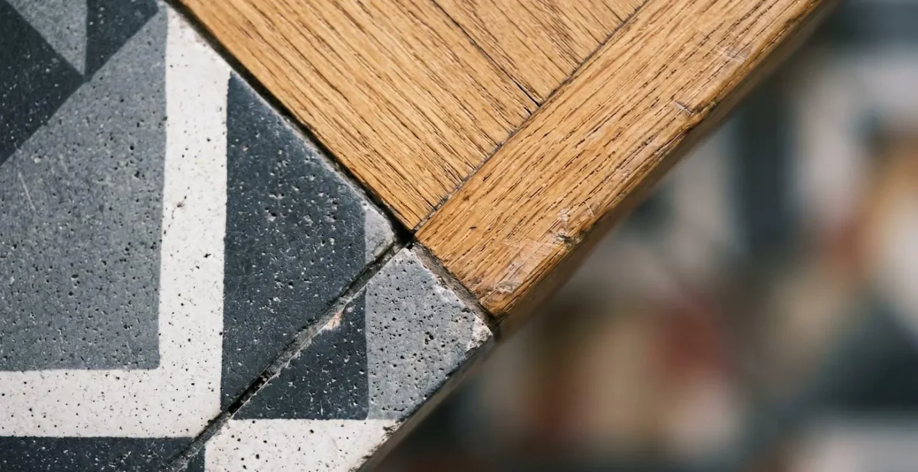 Transition entre parquet point de Hongrie et carreaux de ciment à motifs géométriques dans une entrée